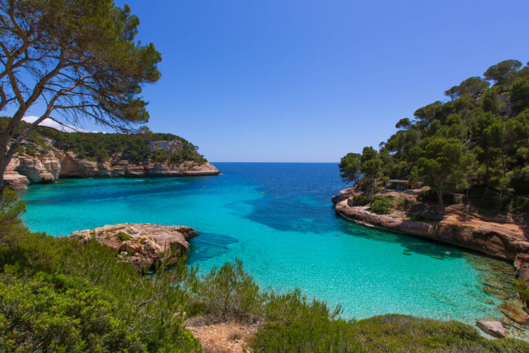 Vista panorâmica da Praia de Menorca, com águas cristalinas rodeada da natureza