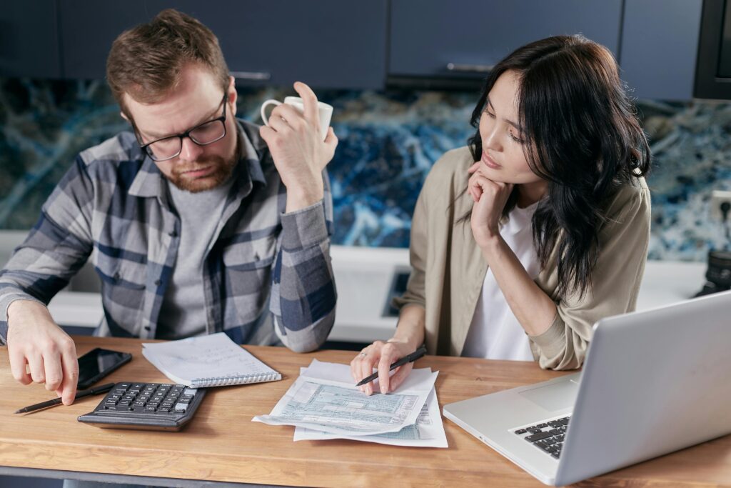 Um casal sentado à mesa a fazer contas sobre quanto tempo demora o reembolso do irs