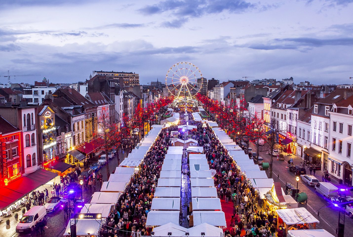 Mercado de Natal em Bruxelas, Bélgica, com a Grand Place iluminada e barraquinhas cheias de waffles e vin chaud.