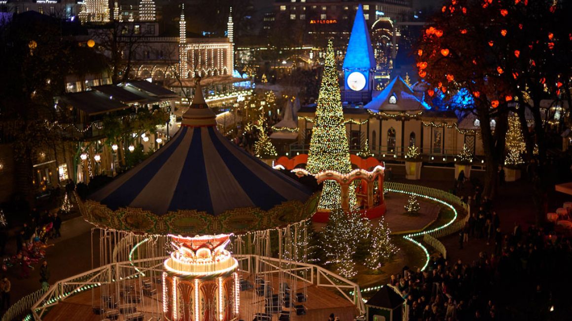 Mercado de Natal nos Jardins Tivoli em Copenhaga, com neve artificial, luzes coloridas e atrações natalícias.